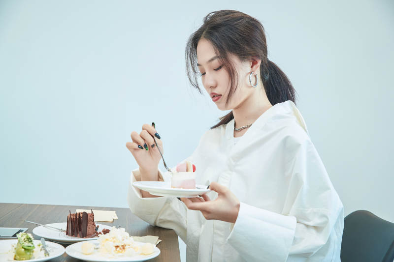 在烘焙店吃蛋糕喝饮料的可爱亚洲少女图片