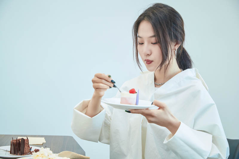 在烘焙店吃蛋糕喝饮料的可爱亚洲少女图片