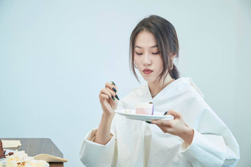 在烘焙店吃蛋糕喝饮料的可爱亚洲少女图片