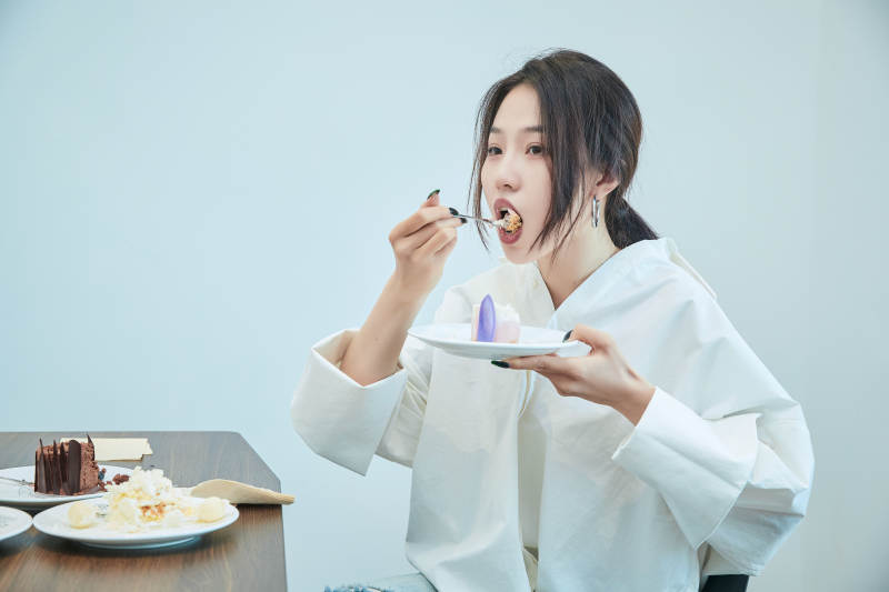 在烘焙店吃蛋糕喝饮料的可爱亚洲少女图片