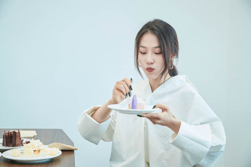 在烘焙店吃蛋糕喝饮料的可爱亚洲少女图片