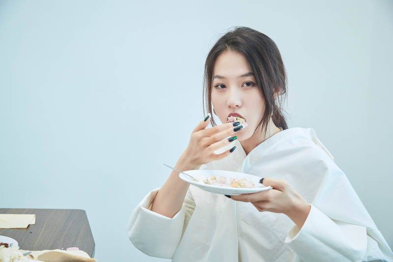 在烘焙店吃蛋糕喝饮料的可爱亚洲少女图片