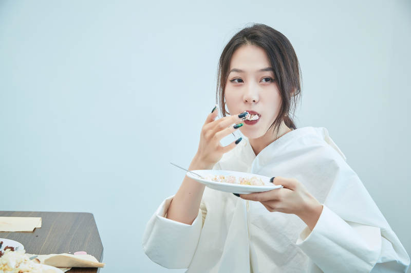 在烘焙店吃蛋糕喝饮料的可爱亚洲少女图片