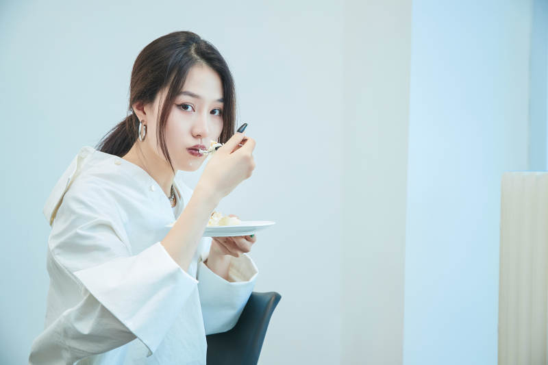 在烘焙店吃蛋糕喝饮料的可爱亚洲少女图片