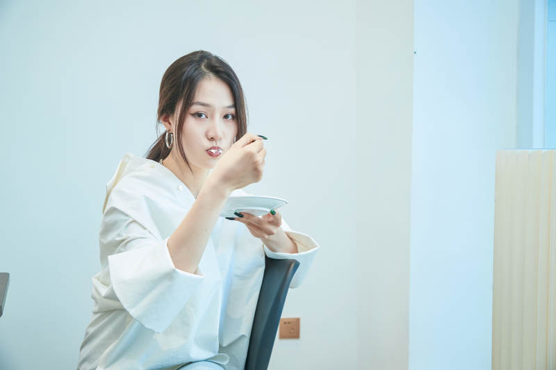 在烘焙店吃蛋糕喝饮料的可爱亚洲少女图片