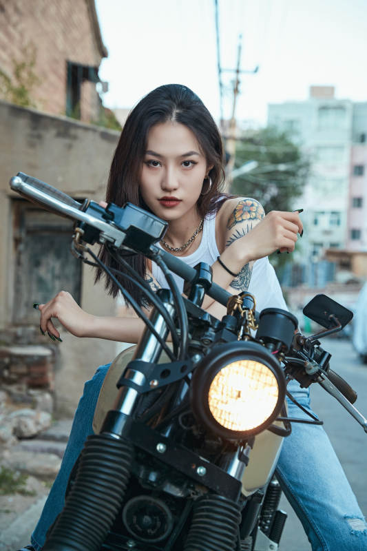 骑在复古摩托车上的时尚亚洲少女图片