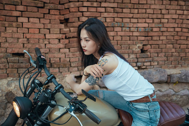 骑在复古摩托车上的时尚亚洲少女图片
