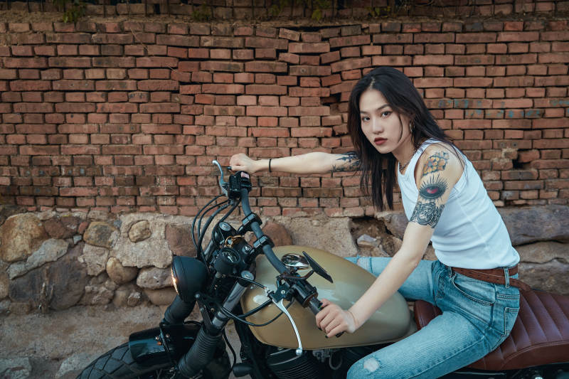 骑在复古摩托车上的时尚亚洲少女图片