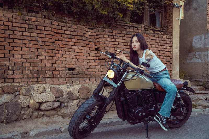 骑在复古摩托车上的时尚亚洲少女图片