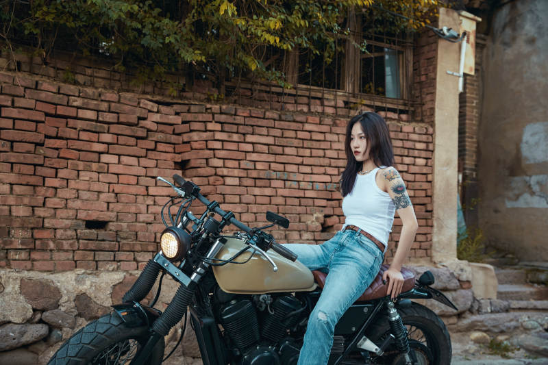 骑在复古摩托车上的时尚亚洲少女图片