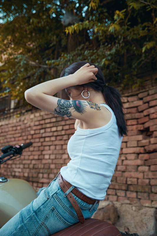 骑在复古摩托车上的时尚亚洲少女图片