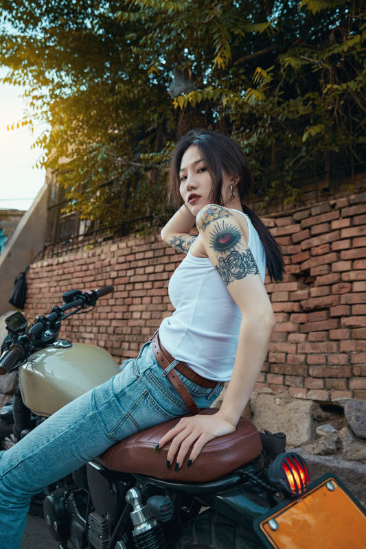 骑在复古摩托车上的时尚亚洲少女图片