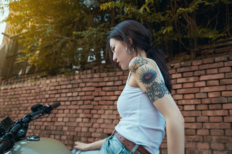 骑在复古摩托车上的时尚亚洲少女图片