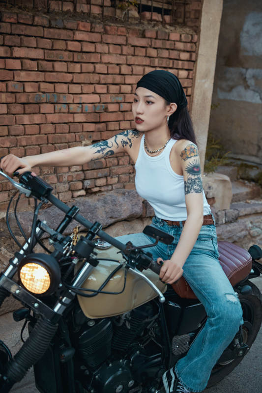 骑在复古摩托车上的时尚亚洲少女图片
