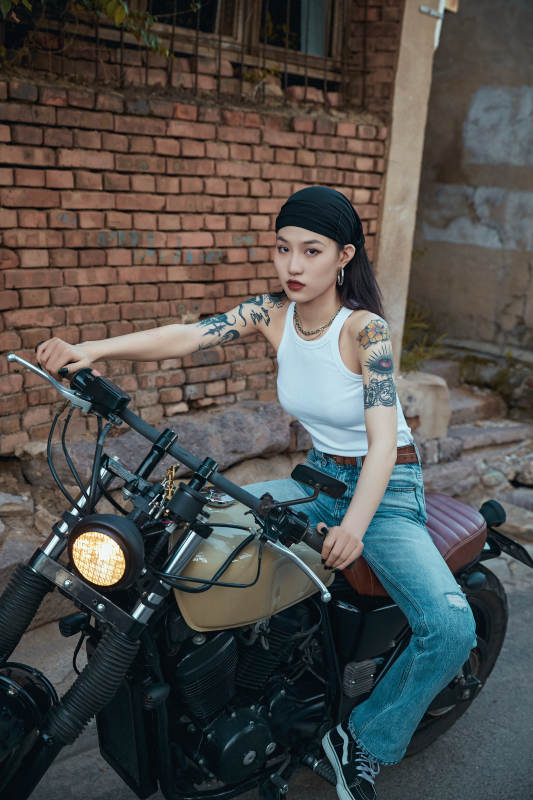 骑在复古摩托车上的时尚亚洲少女图片