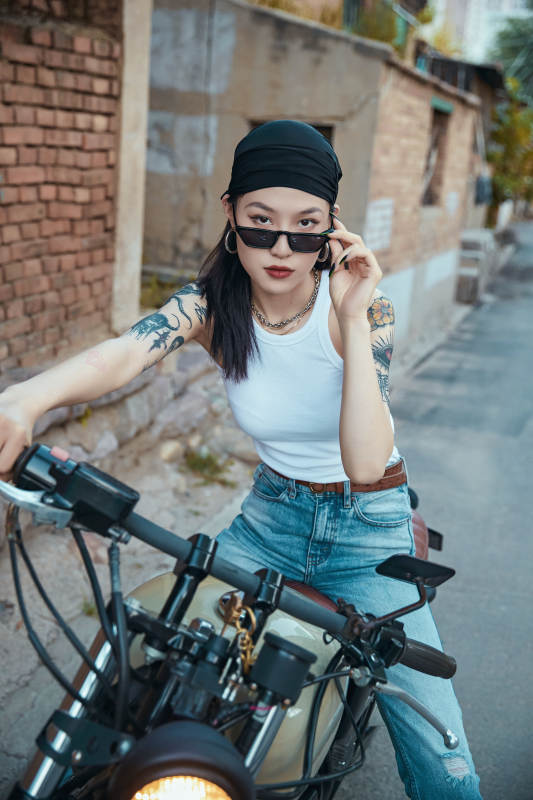 骑在复古摩托车上的时尚亚洲少女图片