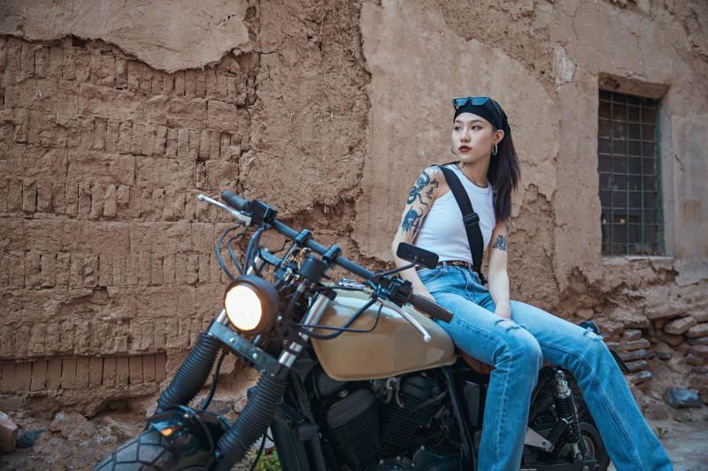 骑在复古摩托车上的时尚亚洲少女图片