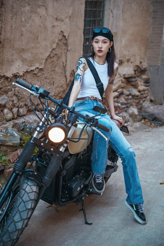 骑在复古摩托车上的时尚亚洲少女图片