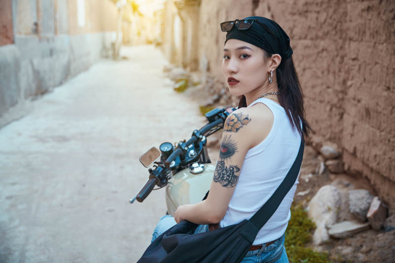 骑在复古摩托车上的时尚亚洲少女图片