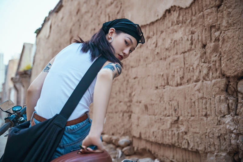 骑在复古摩托车上的时尚亚洲少女图片