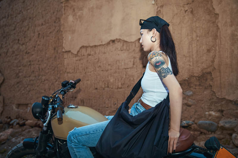 骑在复古摩托车上的时尚亚洲少女图片