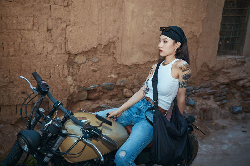 骑在复古摩托车上的时尚亚洲少女图片