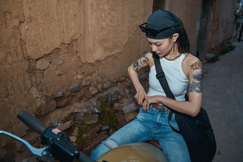 骑在复古摩托车上的时尚亚洲少女图片