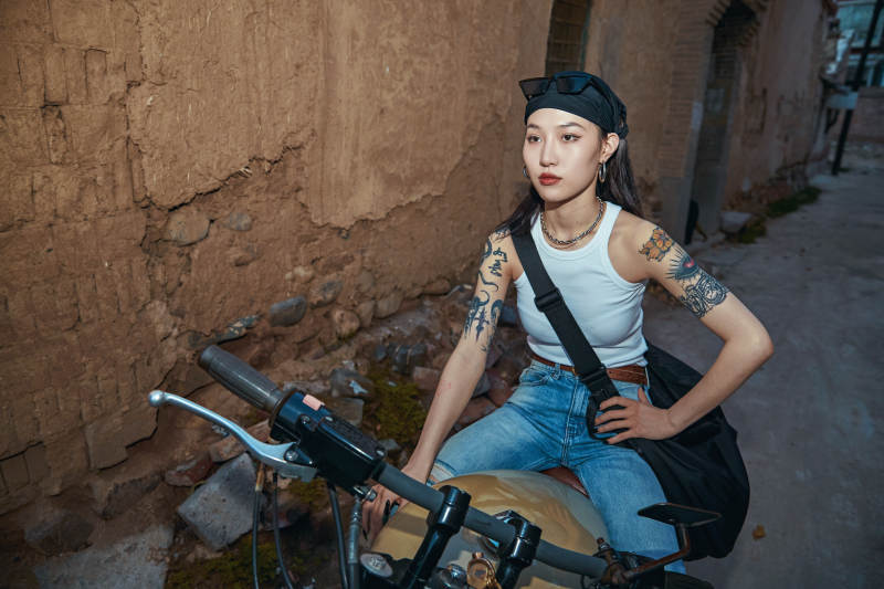 骑在复古摩托车上的时尚亚洲少女图片