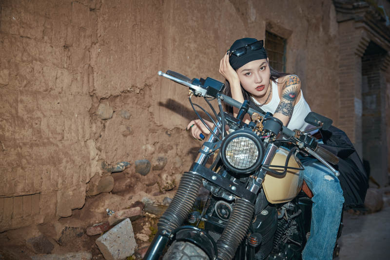 骑在复古摩托车上的时尚亚洲少女图片