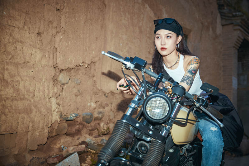 骑在复古摩托车上的时尚亚洲少女图片