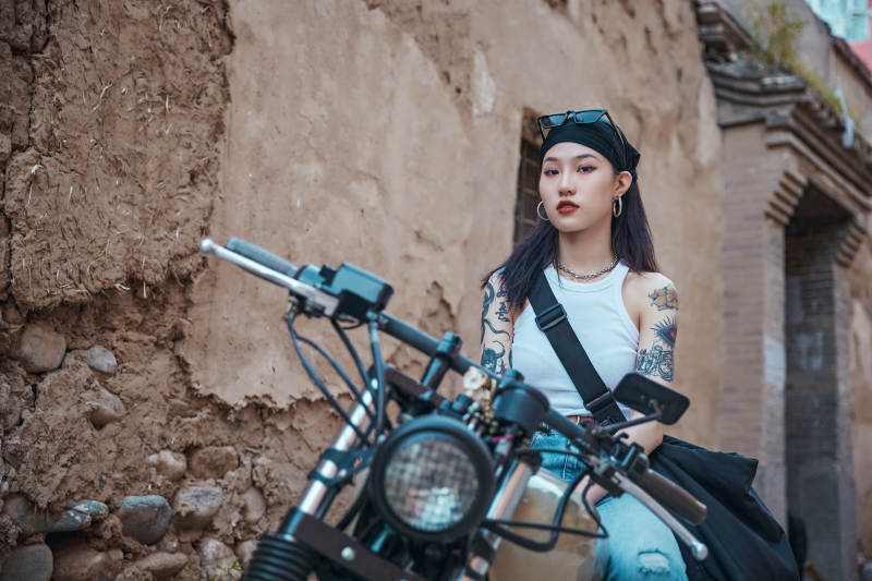 骑在复古摩托车上的时尚亚洲少女图片