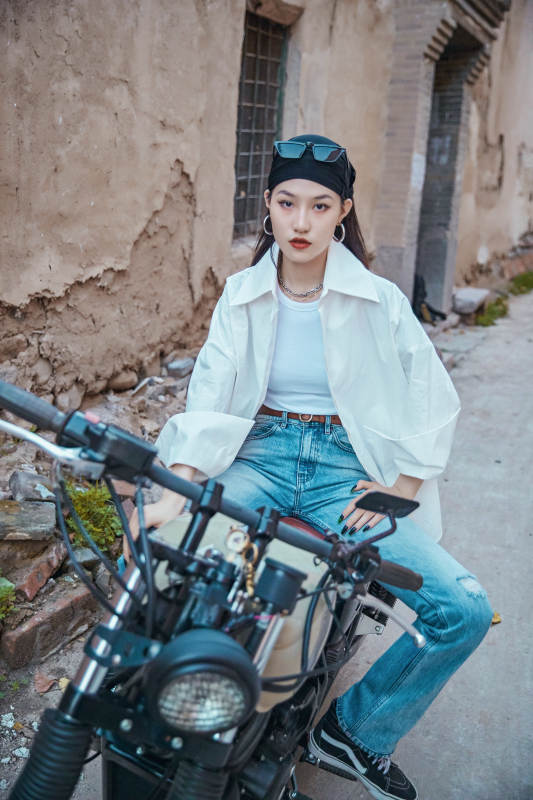 骑在复古摩托车上的时尚亚洲少女图片