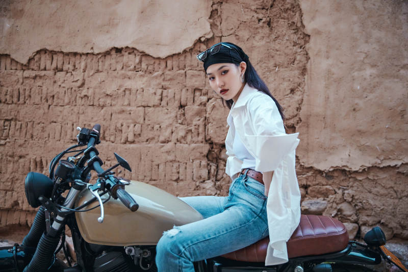 骑在复古摩托车上的时尚亚洲少女图片