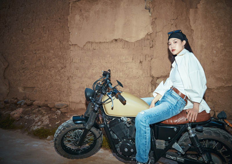 骑在复古摩托车上的时尚亚洲少女图片