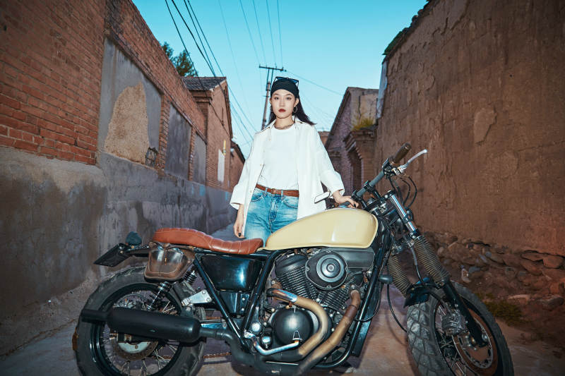 骑在复古摩托车上的时尚亚洲少女图片