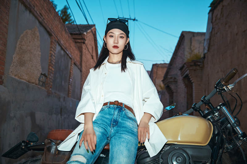 骑在复古摩托车上的时尚亚洲少女图片