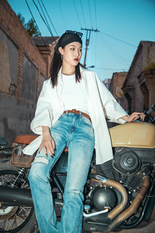 骑在复古摩托车上的时尚亚洲少女图片