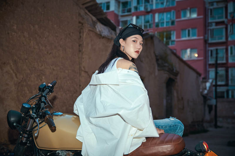 骑在复古摩托车上的时尚亚洲少女图片