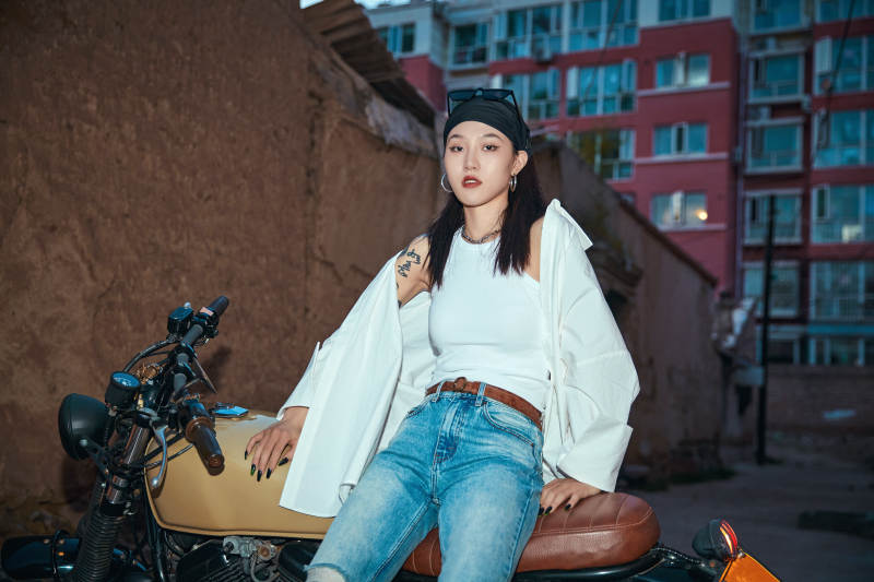 骑在复古摩托车上的时尚亚洲少女图片
