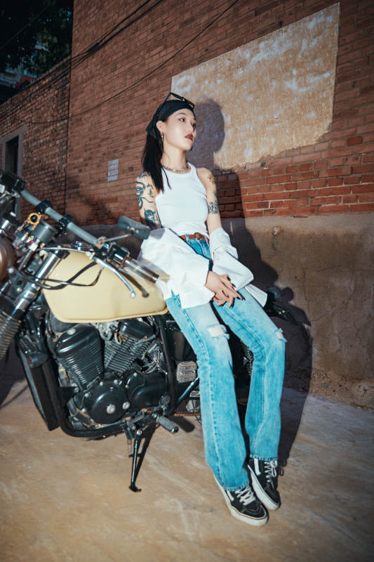骑在复古摩托车上的时尚亚洲少女图片