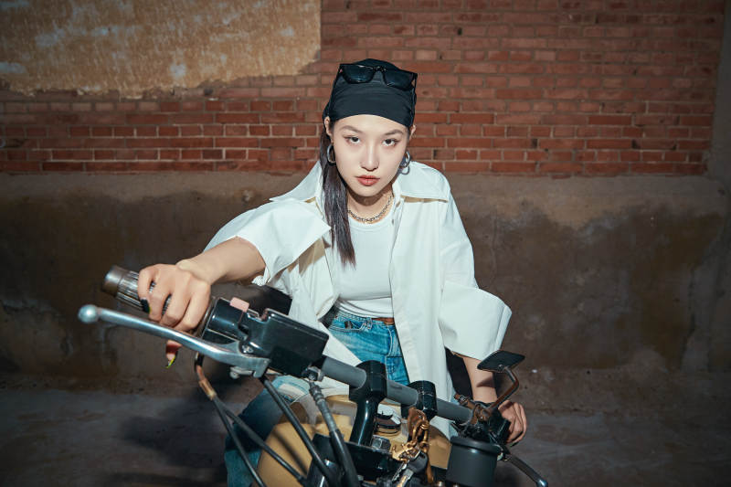 骑在复古摩托车上的时尚亚洲少女图片