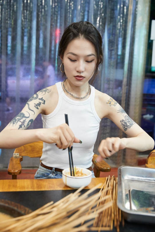 在饭馆吃成都串串的亚洲少女图片