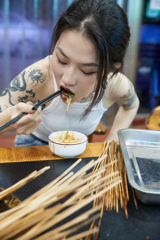 在饭馆吃成都串串的亚洲少女图片