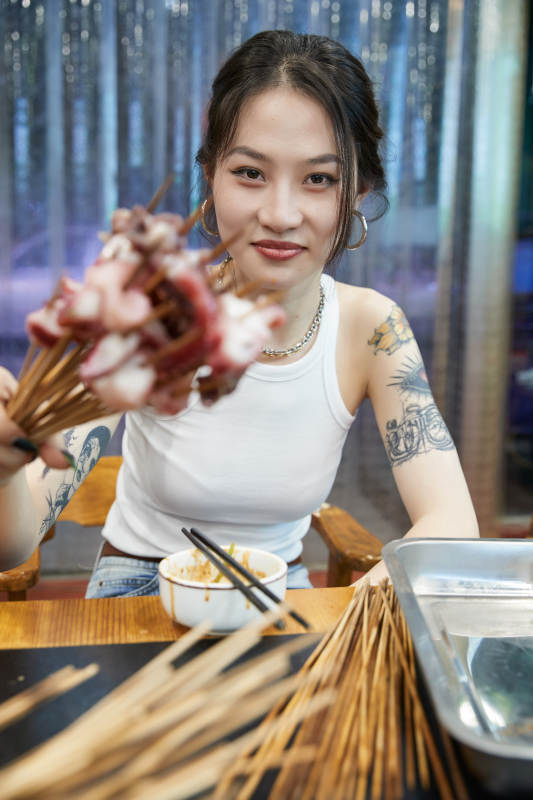 在饭馆吃成都串串的亚洲少女图片