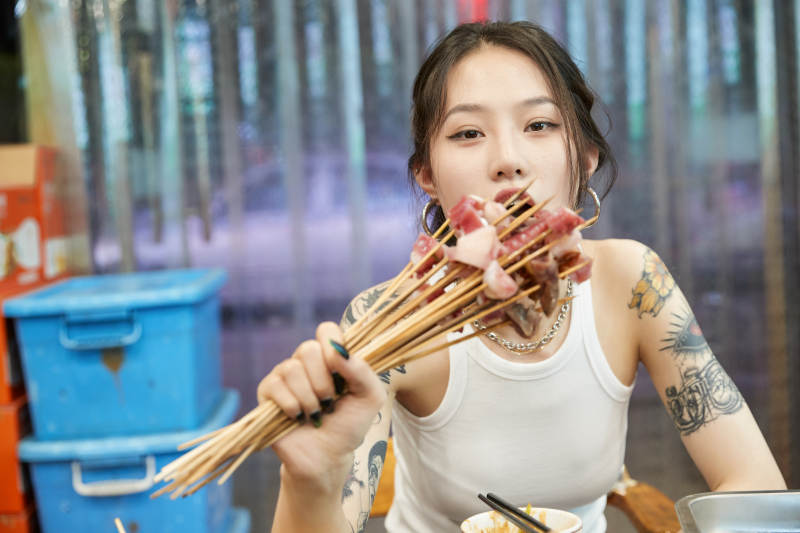 在饭馆吃成都串串的亚洲少女图片