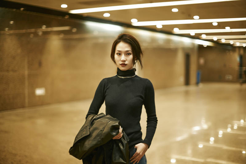 夜晚地下通道内停留的美丽少女图片