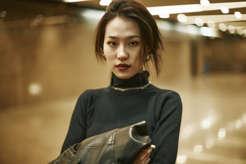 夜晚地下通道内停留的美丽少女图片