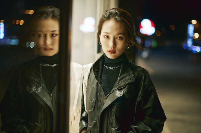 夜晚站立在橱窗外的亚洲少女图片