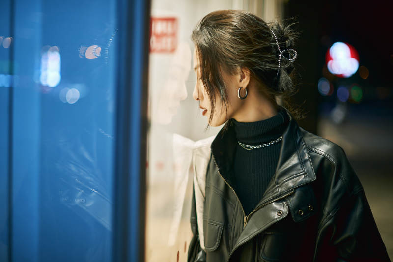 夜晚站立在橱窗外的亚洲少女图片