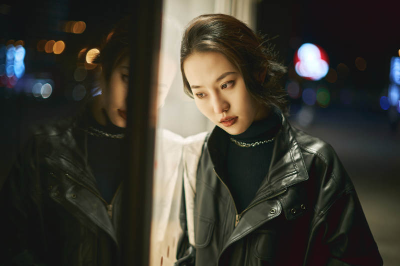夜晚站立在橱窗外的亚洲少女图片
